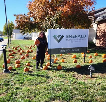 Resident posing outside the facility with pumpkins