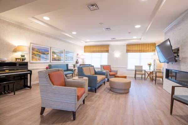 Bright common area with comfortable seating and piano