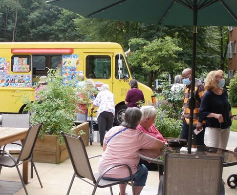 Residents enjoying an outdoor space with a food truck