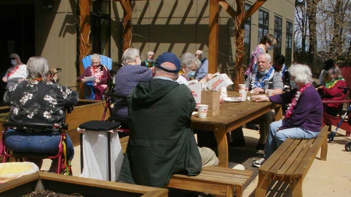 Residents enjoying a meal outdoors during a gathering