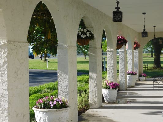 Porch with arches and colorful flower pots at Harrison House of Snow Hill