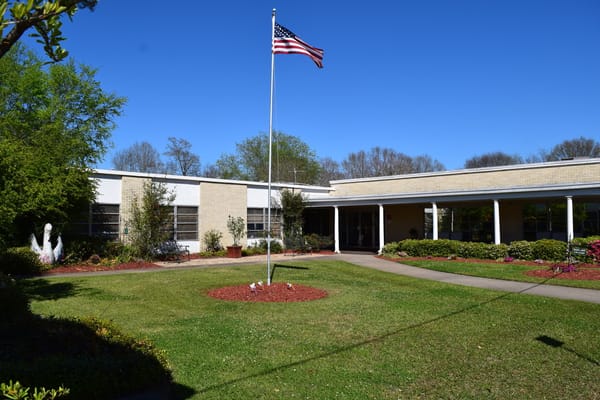 Exterior view of the facility with a flag and landscaping