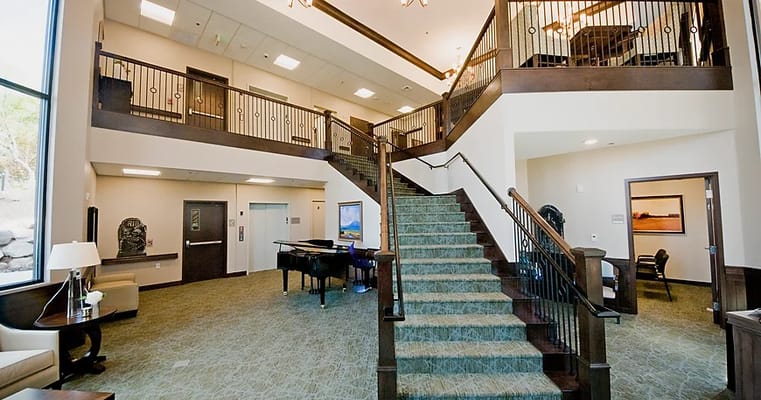 Bright and welcoming lobby area with a staircase and piano
