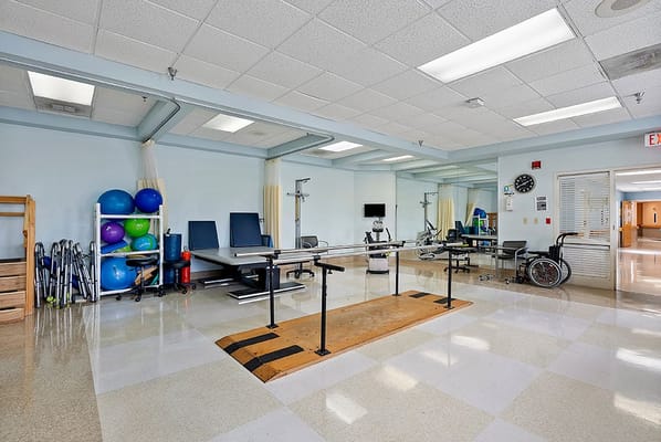 Well-equipped therapy room with exercise equipment and rehabilitation tools
