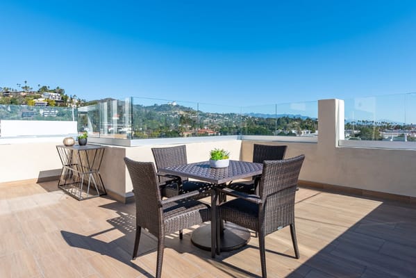 Dining table and chairs on the rooftop terrace overlooking hills