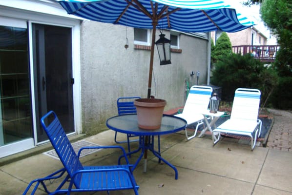 Patio with blue chairs and striped umbrella