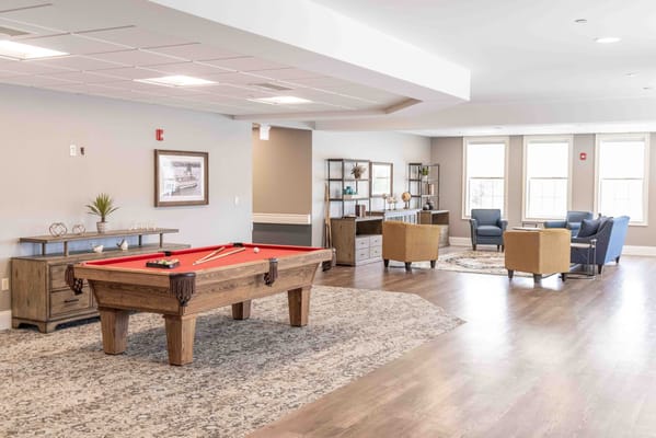 Billiards table in a lounge area with seating and decor.