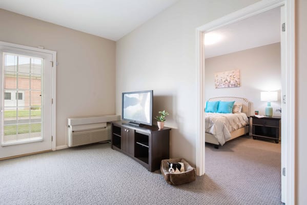 A cozy resident room with a TV and bed