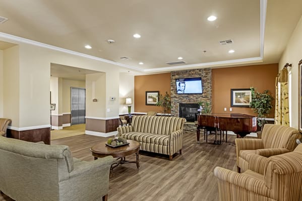 A cozy common area with seating and a piano