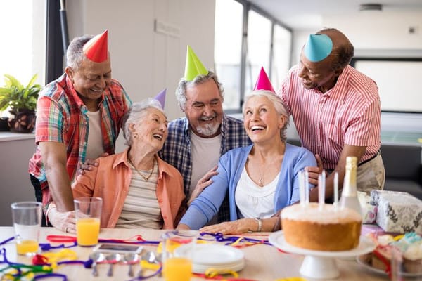Seniors celebrating a birthday with party hats and cake