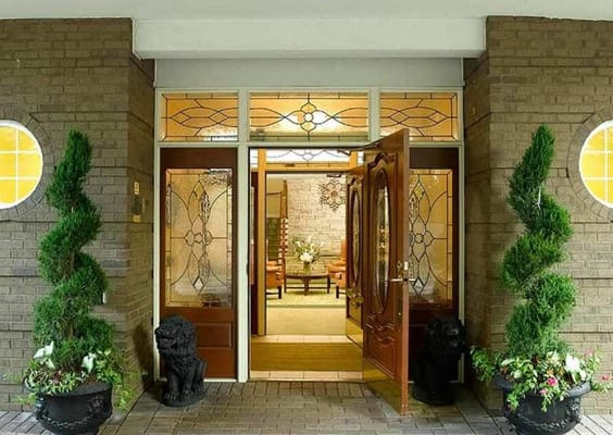 Main entrance with decorative doors and potted plants