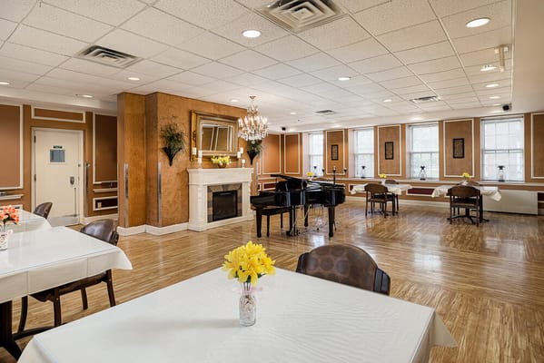Bright common area with piano and tables