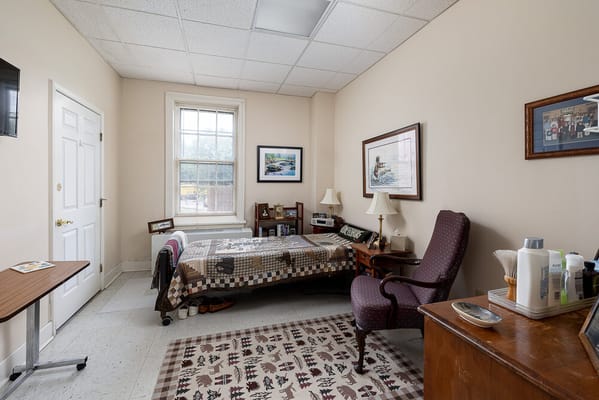 Cozy resident room with a bed, chair, and personal items