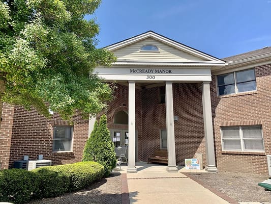 Front entrance of McCready Manor with columns and signage