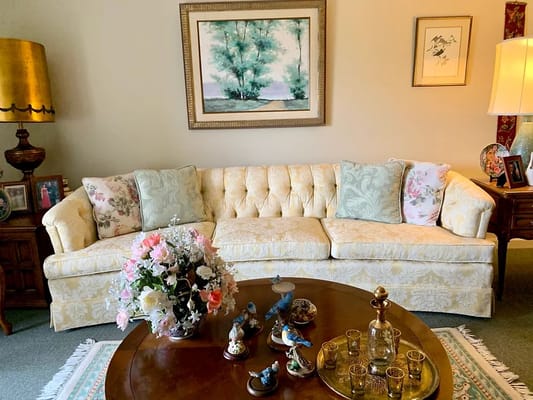 Comfortable yellow sofa with decorative pillows and a coffee table in a living room.