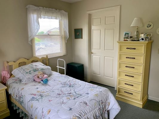 A well-furnished bedroom with a bed, dresser, and decorative items