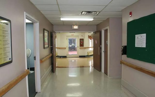 Interior view of a hallway with exit sign and multiple doorways.