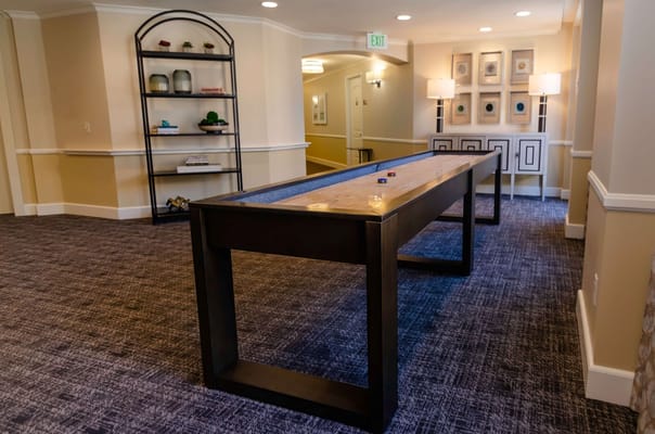 A game table in a common area with decorative shelves.