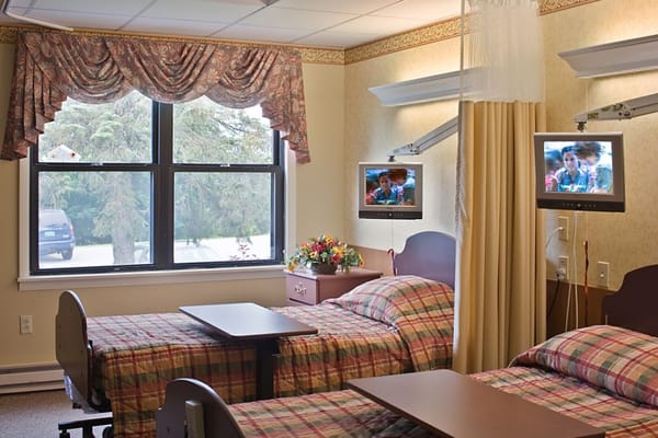Bright resident room with two beds and TVs