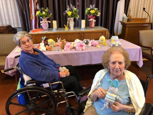 Two residents with stuffed animals at a festive table