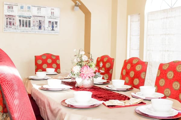 Dining table set with red chairs and floral centerpiece