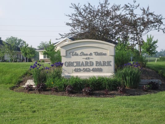 Sign for Orchard Park Assisted Living surrounded by flowers