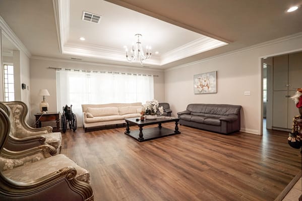 Cozy living room with a sofa, armchairs, and natural light.