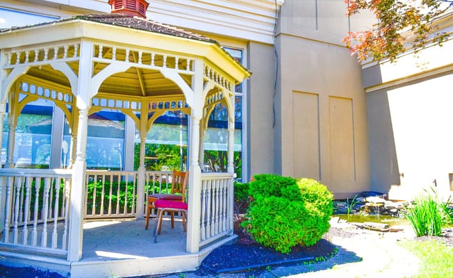 Outdoor gazebo with seating and greenery