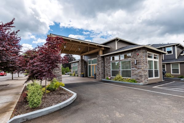 Front entrance of River Terrace Memory Care facility with landscaped gardens