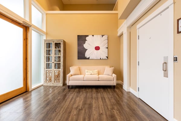 Welcoming lobby with a sofa and floral artwork.