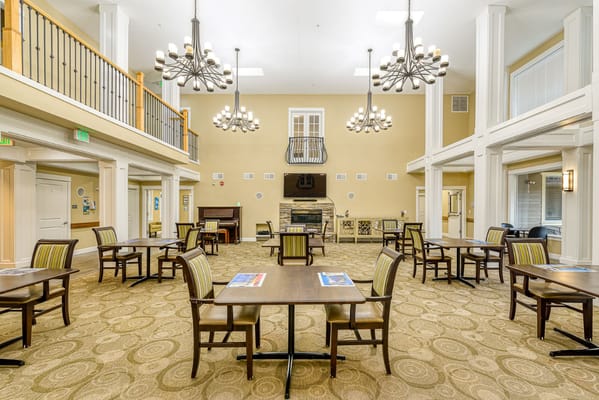 Spacious common area with tables and chairs in River Terrace Memory Care