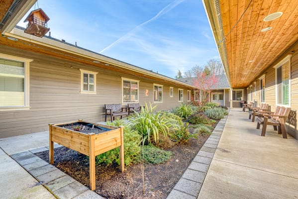 A view of the courtyard with a planter and benches at River Terrace Memory Care.