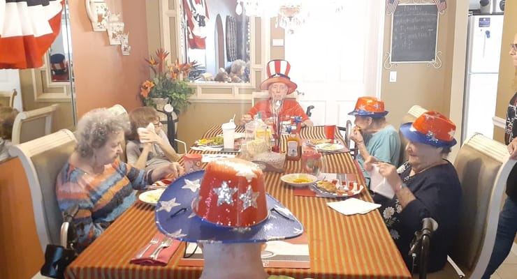 Seniors celebrating with festive hats at a dining table