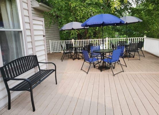 Seating area with tables and umbrellas on a wooden patio