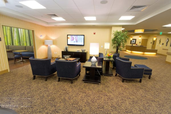 Cozy seating area with blue chairs and a TV in a lobby