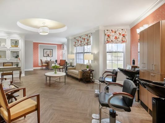 Bright and welcoming common area with seating and hair styling stations.