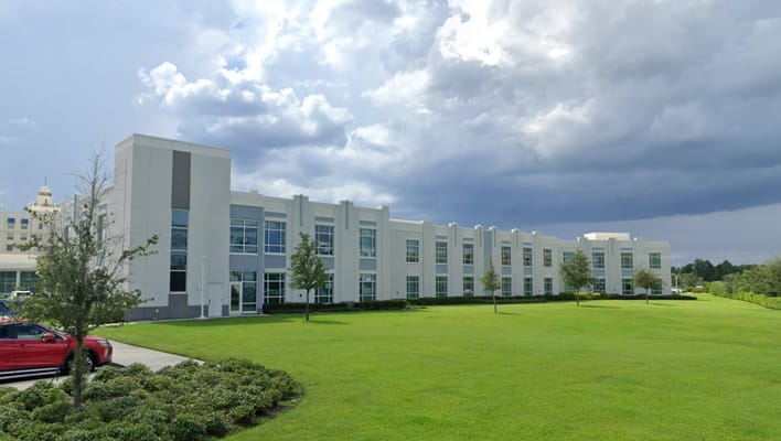 Exterior of Solaris Healthcare Celebration facility with green lawn and cloudy sky.