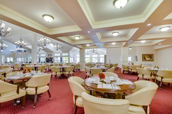 Dining room with tables set for meals in a retirement facility