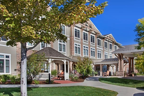 Exterior of Sunrise at FlatIrons senior living facility with pathways and landscaping.