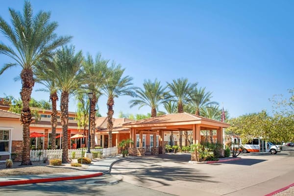 Welcoming entrance of Sunrise of Chandler with palm trees.