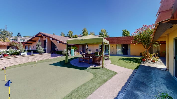 Outdoor seating area with a gazebo and well-maintained gardens