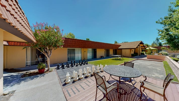 Outdoor seating area with large chess set and greenery