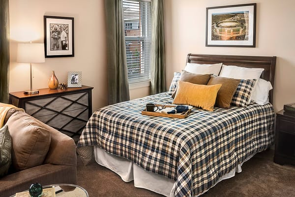 Well-furnished bedroom with a bed, lamp, and decorative items