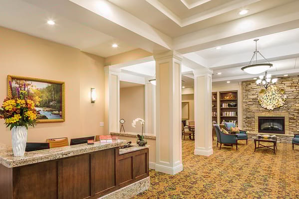 Lobby area with reception desk, floral arrangement, and seating