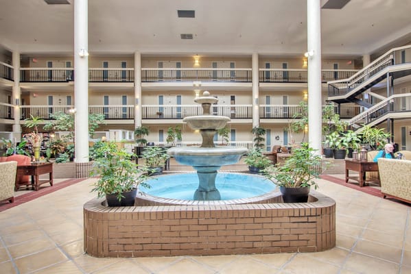 Indoor fountain surrounded by plants and seating at The Atrium of Belleville