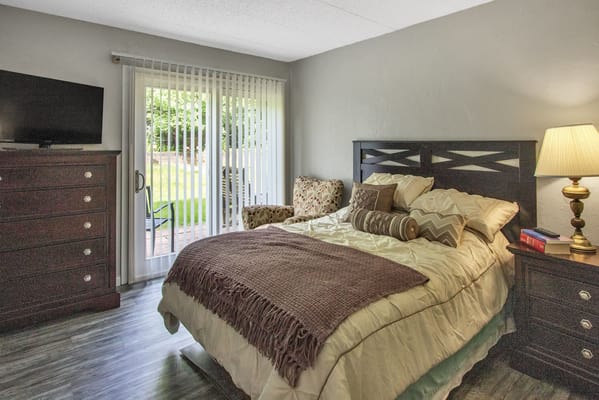Cozy bedroom with a bed, dresser, and view of the garden
