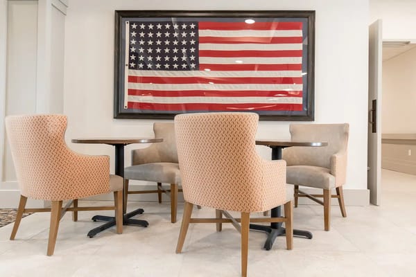 Seating area featuring plush chairs and an American flag