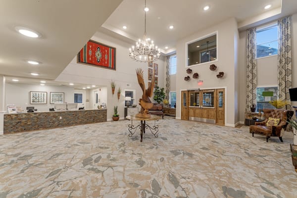 Spacious lobby with a decorative chandelier and wooden sculpture