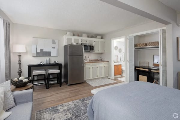 Interior view of a studio apartment featuring a kitchen area and living space.