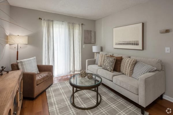 A comfortable living room with a sofa, coffee table, and natural light.